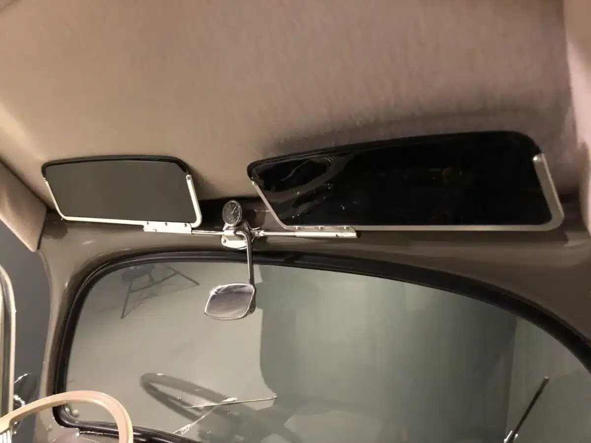 Sonnenblenden und Innenspiegel eines Volkswagen Käfer Ovalfenster 1956 aus der Fahrerperspektive.