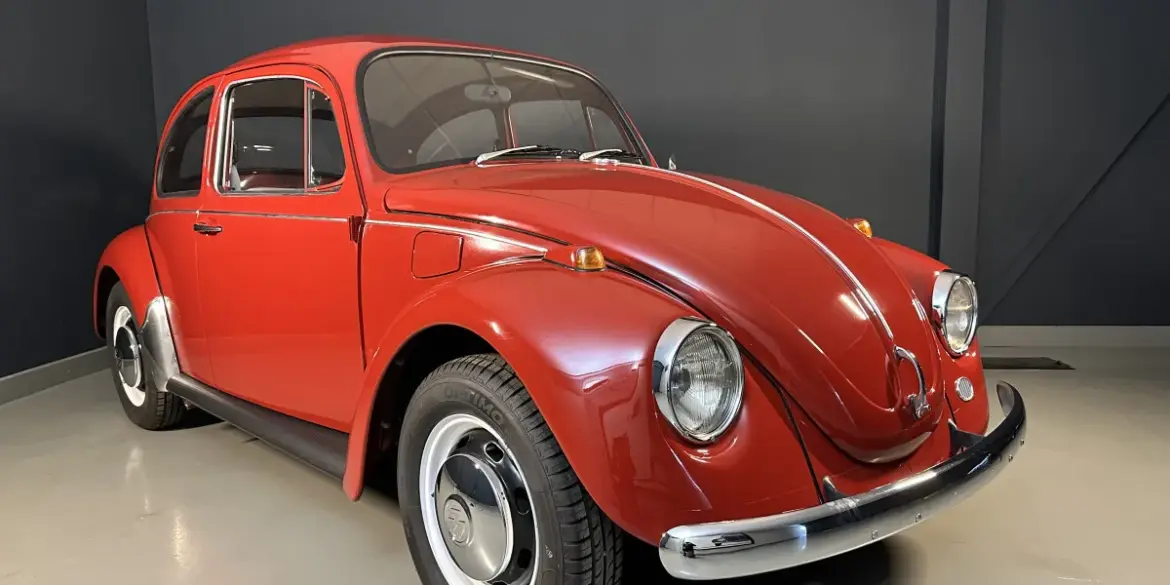 Roter Volkswagen Spaarkever Baujahr 1969 in einer hellen Halle, schräg von vorne fotografiert