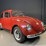 Roter Volkswagen Spaarkever Baujahr 1969 in einer hellen Halle, schräg von vorne fotografiert