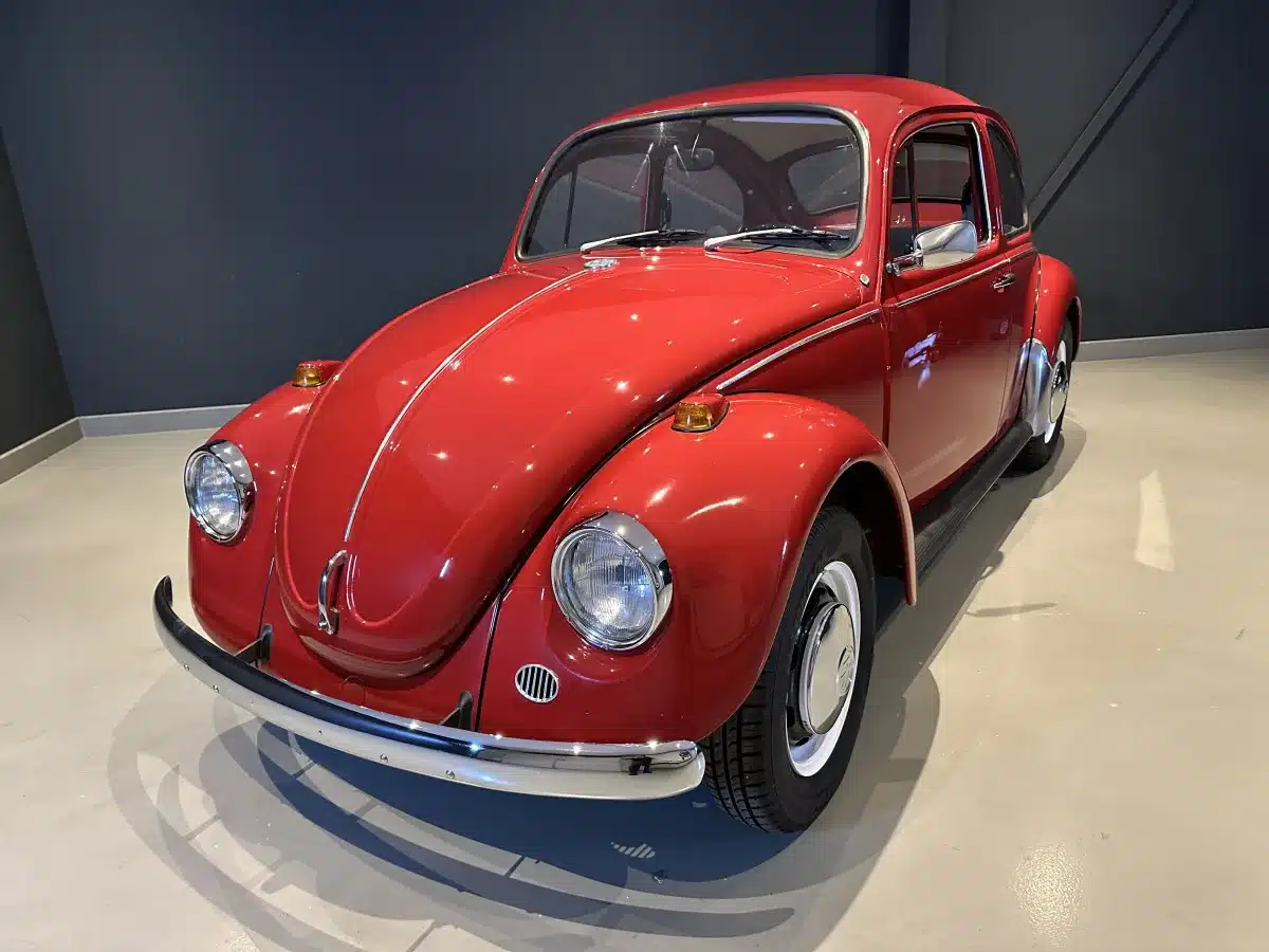 Roter Volkswagen Spaarkever von 1969, spartanische Variante des Käfers, Vorderansicht in heller Halle.