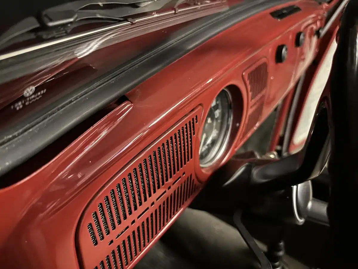 Rotes Armaturenbrett mit Tacho und Lüftungsgittern eines Volkswagen Spaarkever von 1969.