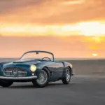 1955 Maserati A6G/54 2000 Spyder Zagato in Blau, offen, vor Sonnenuntergang am Strand.