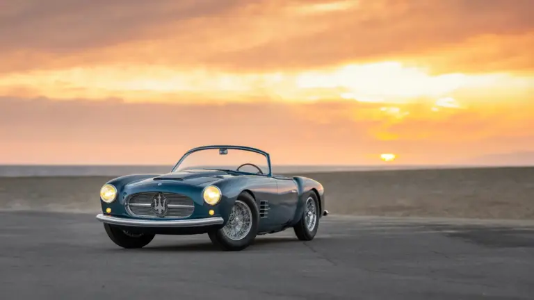 1955 Maserati A6G/54 2000 Spyder Zagato in Blau, offen, vor Sonnenuntergang am Strand.