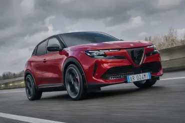 Alfa Romeo Junior Elettrica, rotes kompaktes Elektroauto, fährt dynamisch auf einer Straße