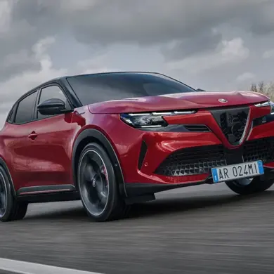 Alfa Romeo Junior Elettrica, rotes kompaktes Elektroauto, fährt dynamisch auf einer Straße