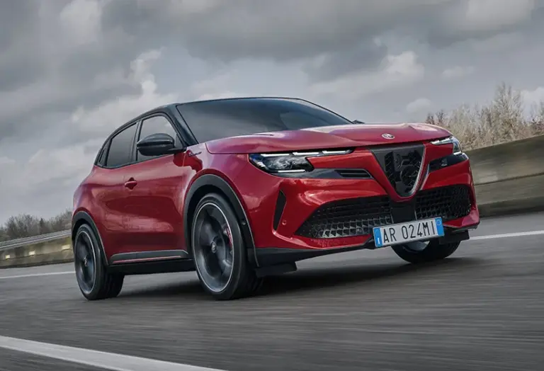 Alfa Romeo Junior Elettrica, rotes kompaktes Elektroauto, fährt dynamisch auf einer Straße