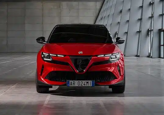 Frontansicht des Alfa Romeo Junior Elettrica in Rot in moderner Umgebung