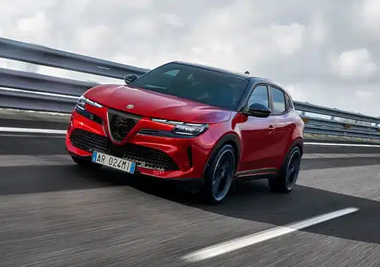 Alfa Romeo Junior Elettrica in leuchtendem Rot fährt dynamisch auf einer Schnellstraße