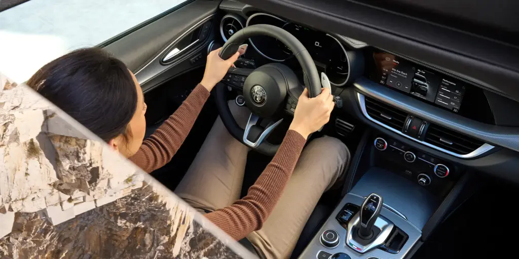 Innenansicht des Alfa Romeo Stelvio mit Blick auf Lenkrad, Armaturenbrett und zentrale Bedienelemente
