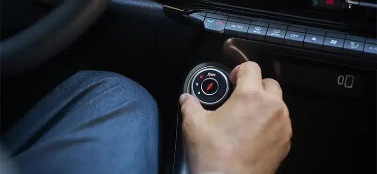 Hand am DNA-Fahrmodus-Drehschalter des Alfa Romeo Tonale in der Mittelkonsole