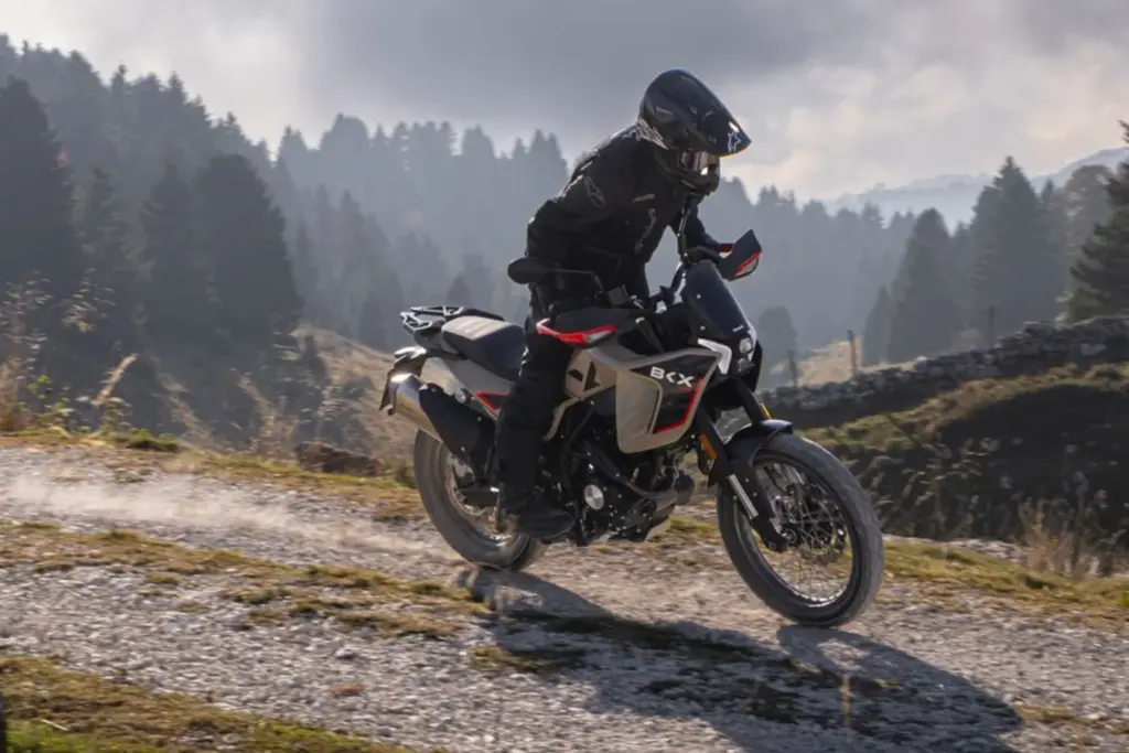 Benelli BKX 125 Adventure-Motorrad wird von einem Fahrer auf Schotter im Gelände bewegt.