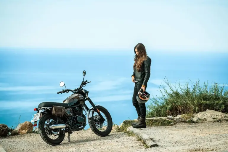 Motorrad Brixton Cromwell 125 mit Fahrerin vor Meer