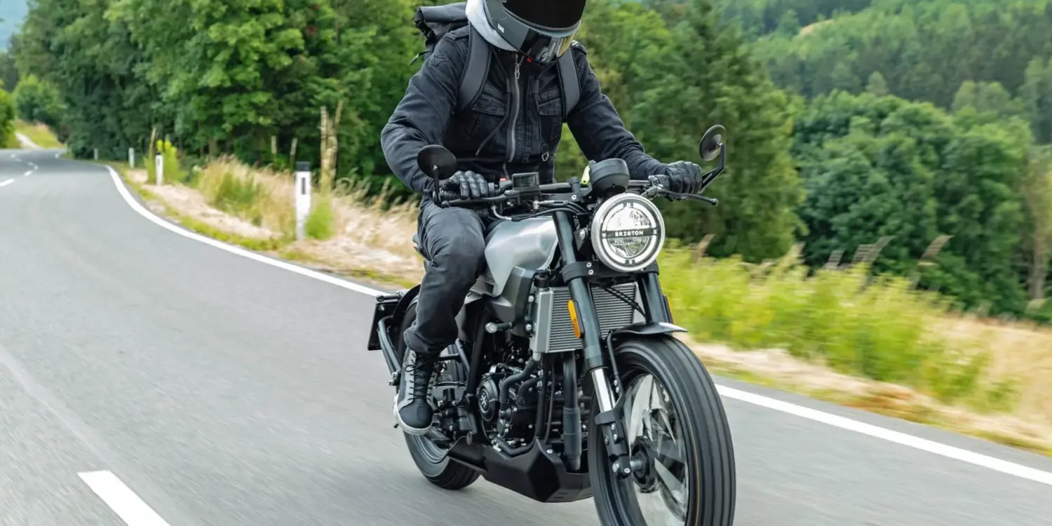 Brixton Crossfire 125 Motorrad wird von einem Fahrer auf einer Landstraße gefahren