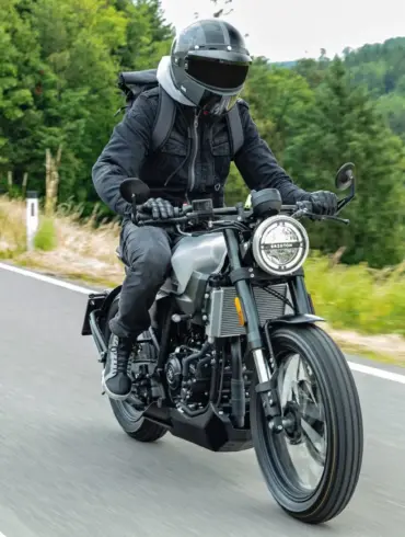 Brixton Crossfire 125 Motorrad wird von einem Fahrer auf einer Landstraße gefahren