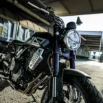 Nahaufnahme der Brixton Crossfire 500 X mit Schwerpunkt auf Front und Motor, urbanes Hintergrundmotiv