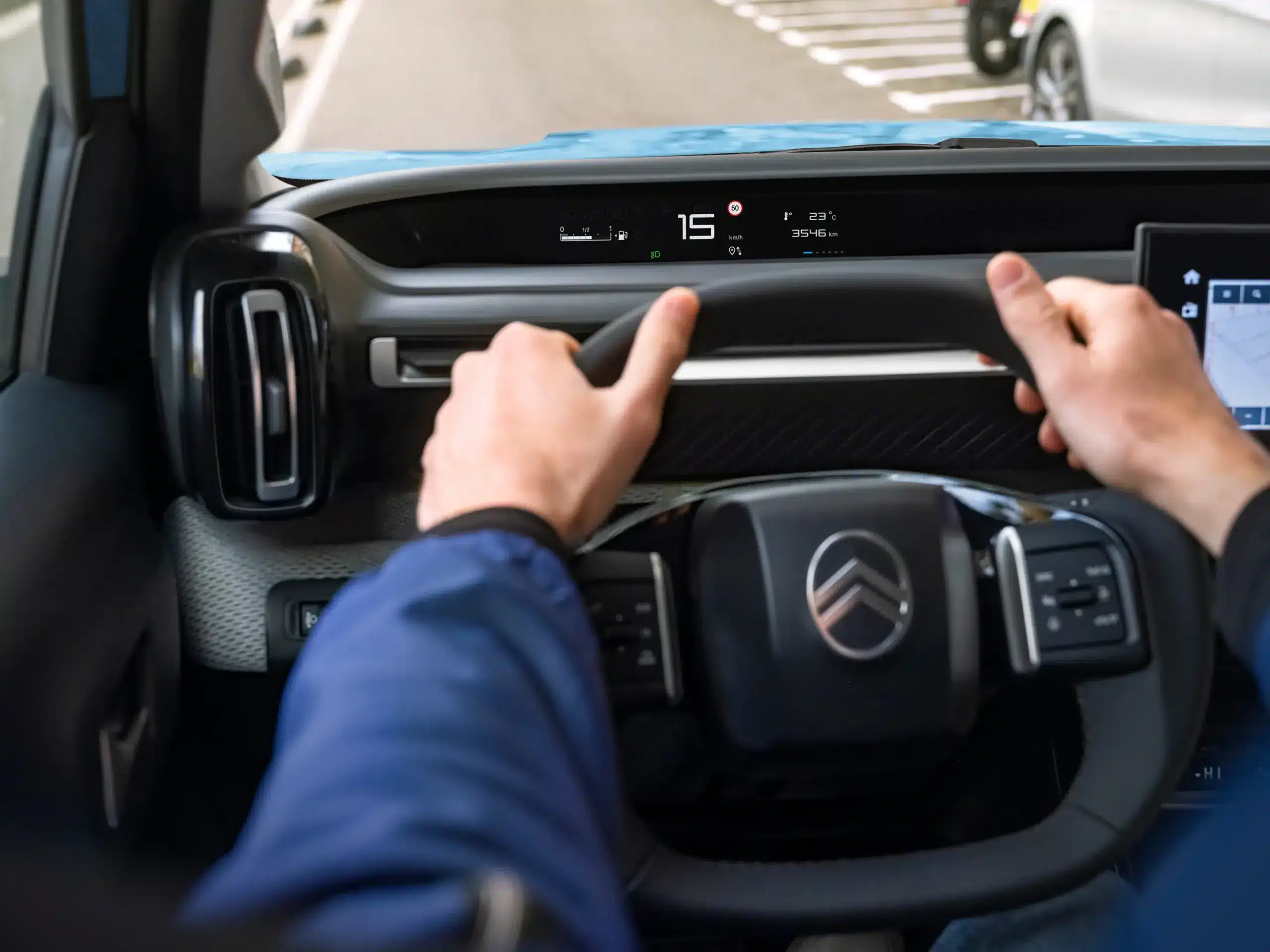 Blick über das Lenkrad auf das digitale Cockpit und Head-up-Display im Citroën ë-C3.