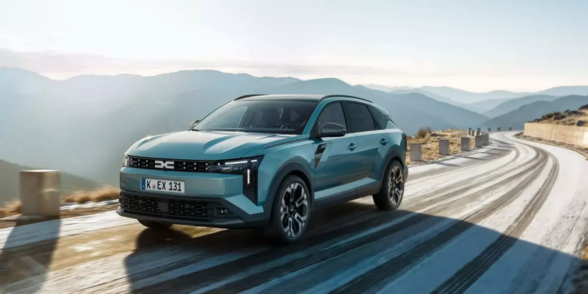 Dacia Striker Hybrid-Crossover fährt auf kurviger Bergstraße bei Tageslicht