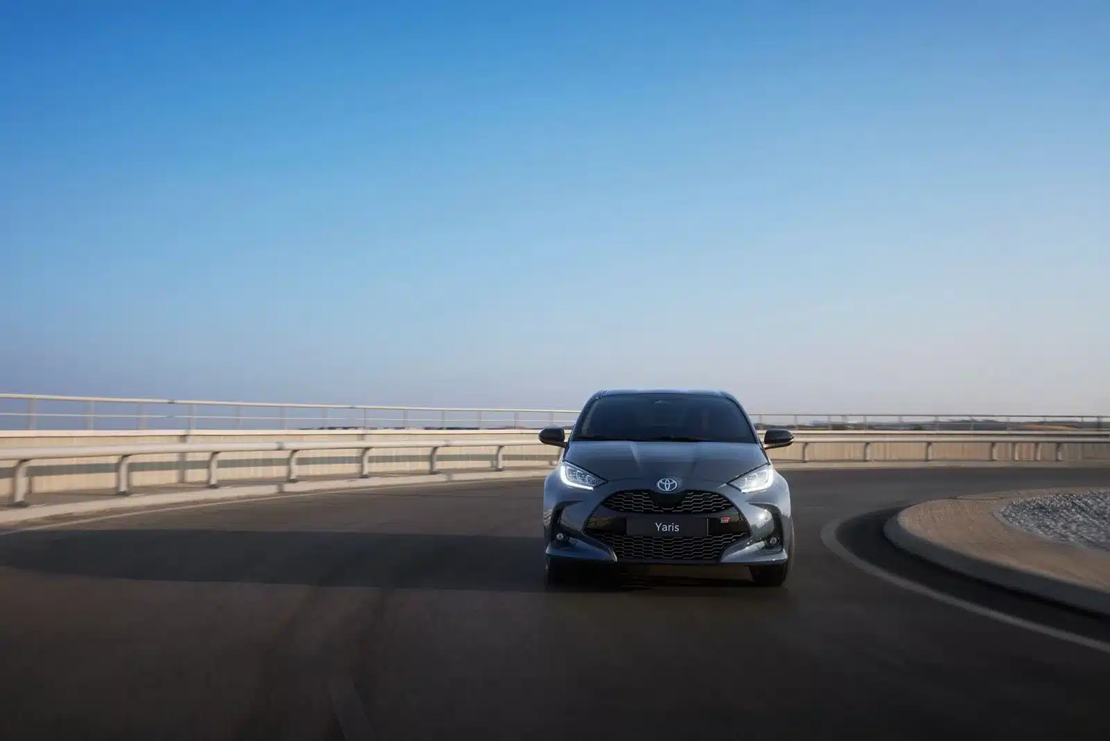 Toyota Yaris von vorn auf einer leeren Straße bei blauem Himmel