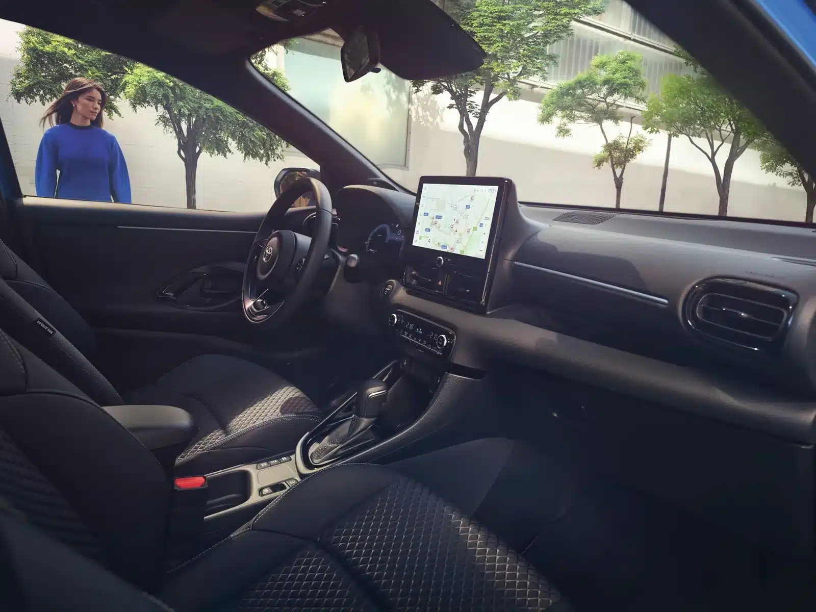 Innenansicht des Toyota Yaris mit Blick auf das Cockpit, das Infotainment-Display und hochwertige Sitze.