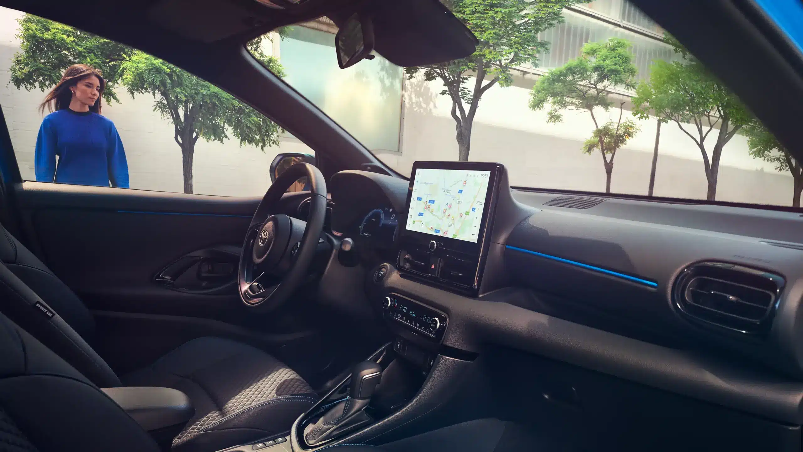 Innenansicht des Toyota Yaris mit großem Multimediasystem, Armaturenbrett und Fahrersitz.