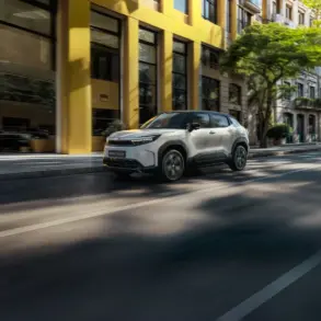 Toyota Urban Cruiser Elektro-SUV fährt auf einer städtischen Straße vor modernen Gebäuden