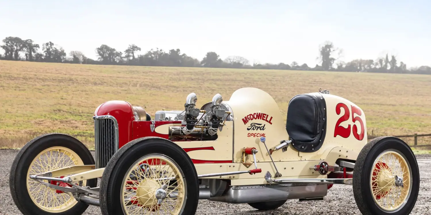 Seitenansicht des 1932 McDowell Ford Special „A“ Sprint Car, historischer Rennwagen mit offener Bauweise und Startnummer 25, aufgenommen auf einem Feldweg vor ländlicher Kulisse