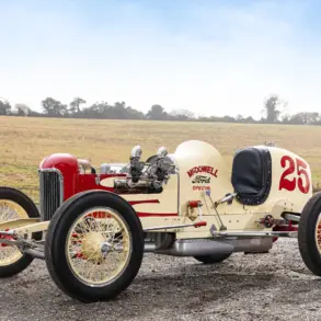 Seitenansicht des 1932 McDowell Ford Special „A“ Sprint Car, historischer Rennwagen mit offener Bauweise und Startnummer 25, aufgenommen auf einem Feldweg vor ländlicher Kulisse