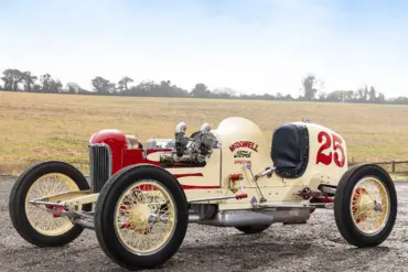 Seitenansicht des 1932 McDowell Ford Special „A“ Sprint Car, historischer Rennwagen mit offener Bauweise und Startnummer 25, aufgenommen auf einem Feldweg vor ländlicher Kulisse