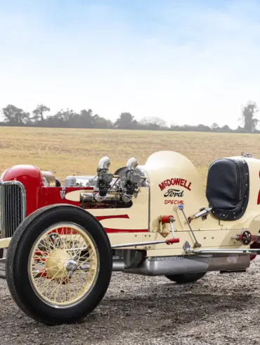 Seitenansicht des 1932 McDowell Ford Special „A“ Sprint Car, historischer Rennwagen mit offener Bauweise und Startnummer 25, aufgenommen auf einem Feldweg vor ländlicher Kulisse