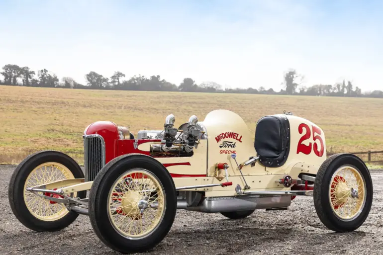 Seitenansicht des 1932 McDowell Ford Special „A“ Sprint Car, historischer Rennwagen mit offener Bauweise und Startnummer 25, aufgenommen auf einem Feldweg vor ländlicher Kulisse