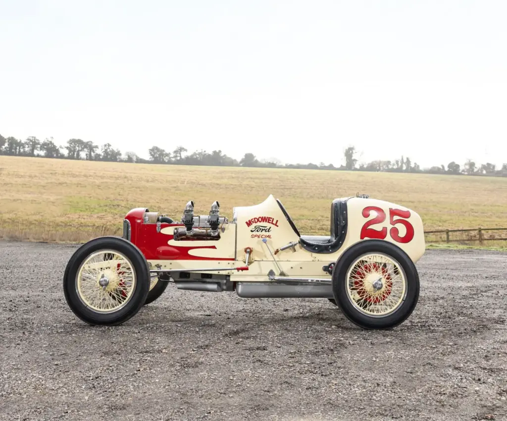 Seitenansicht eines cremefarbenen 1932 McDowell Ford Special „A“ Sprint Cars mit roter Nummer 25 und offener Karosserie im Freien