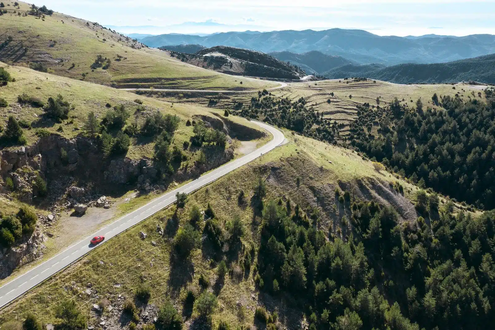 Toyota GR Supra 2025 in rot auf einer kurvenreichen Bergstraße aus der Vogelperspektive