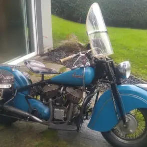 Blaue Indian Chief 1948 mit Windschutzscheibe und Ledersatteltaschen vor Terrasse
