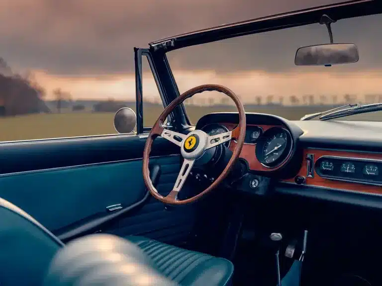 Blick auf das Cockpit und Lenkrad eines Ferrari 275 GTS mit blauer Lederausstattung