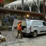 Fiat Doblò 25th Anniversary als Kastenwagen auf einer Baustelle mit offenem Laderaum und Arbeiter mit Baumaterial.