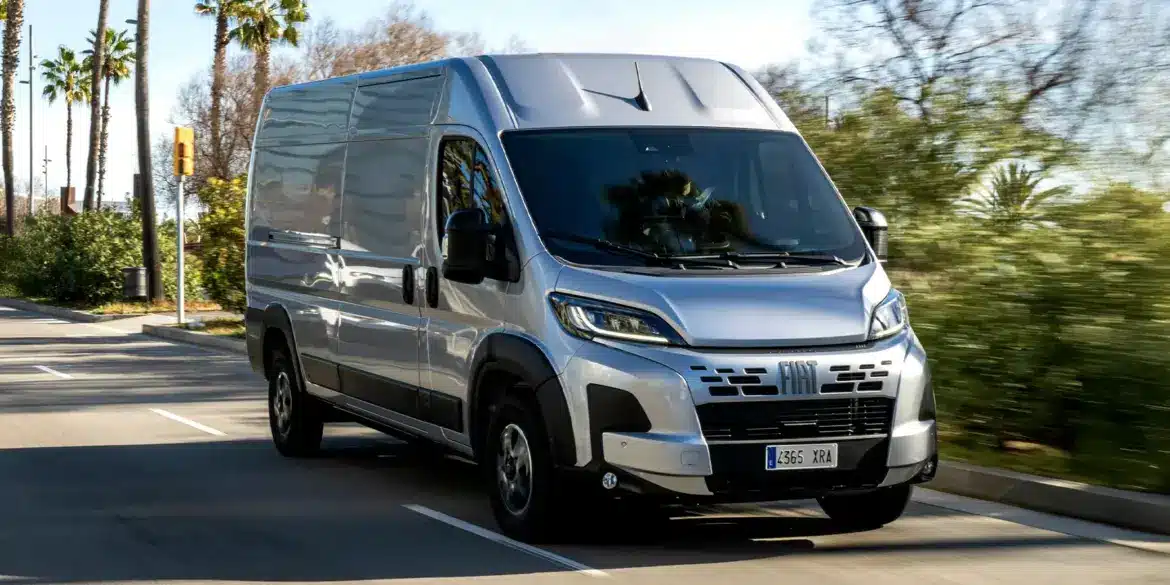 Fiat Ducato Transporter fährt auf einer von Palmen gesäumten Straße