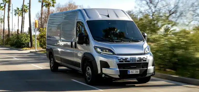 Fiat Ducato Transporter fährt auf einer von Palmen gesäumten Straße