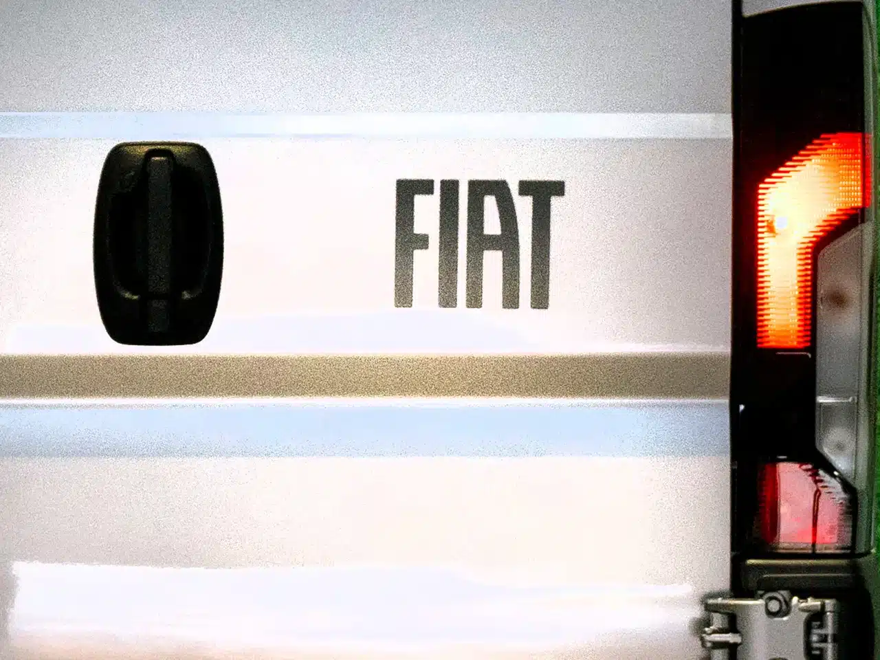 Nahaufnahme der Heckpartie eines Fiat Ducato mit sichtbarem FIAT-Schriftzug und Rücklicht.