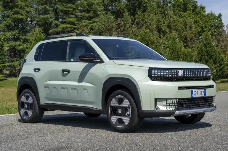 Fiat Grande Panda Benzin in heller Lackierung auf einer Straße, umgeben von Bäumen.