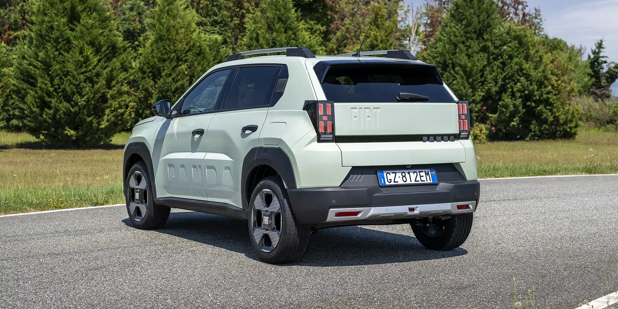 Fiat Grande Panda Benzin in mintgrün auf einer Landstraße, fotografiert von hinten mit gut sichtbaren Leuchten und SUV-Proportionen