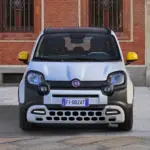 Frontansicht des Fiat Pandina Hybrid in markantem Design vor Backsteinfassade