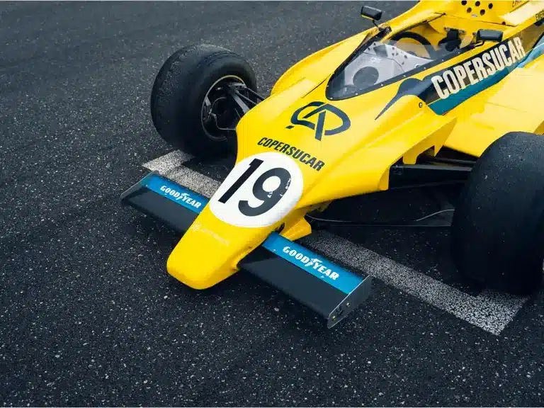 Gelber Fittipaldi F6A Formel-1-Rennwagen von 1979 in Copersucar-Lackierung, vorne rechts in der Boxengasse.
