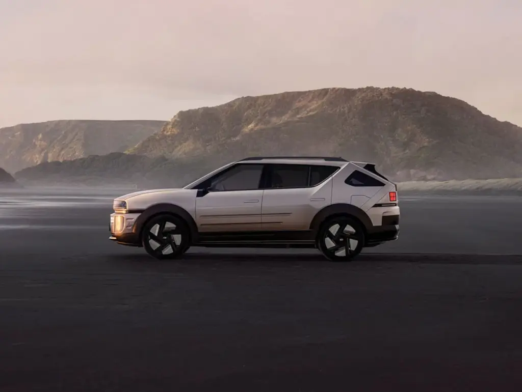 Moderner SUV parkt bei Sonnenuntergang vor einer felsigen Landschaft