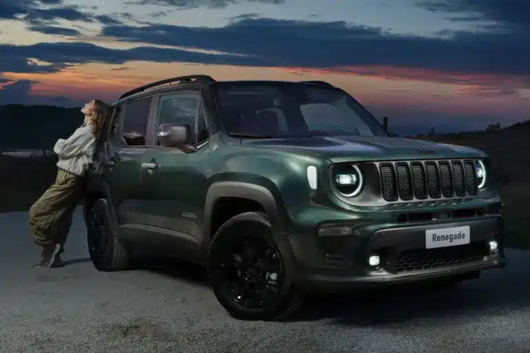 Grüner Jeep Renegade e-Hybrid mit einer Person am Fahrzeug vor abendlicher Landschaft.