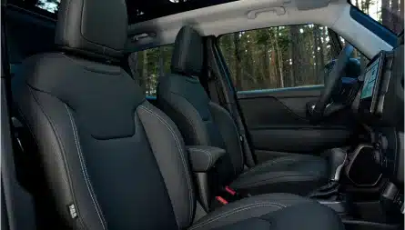 Blick in den Innenraum eines Jeep Renegade e-Hybrid mit zwei Vordersitzen und offenem Panorama-Glasschiebedach.