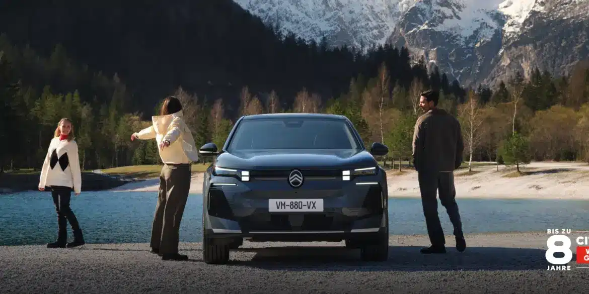 Frontansicht des Citroën C5 Aircross SUV vor See und Bergen, begleitet von Menschen in Outdoor-Kleidung.