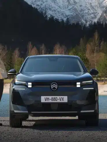 Frontansicht des Citroën C5 Aircross SUV vor See und Bergen, begleitet von Menschen in Outdoor-Kleidung.