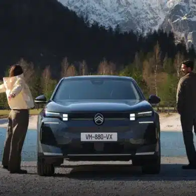 Frontansicht des Citroën C5 Aircross SUV vor See und Bergen, begleitet von Menschen in Outdoor-Kleidung.