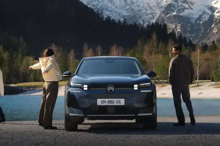 Frontansicht des Citroën C5 Aircross SUV vor See und Bergen, begleitet von Menschen in Outdoor-Kleidung.