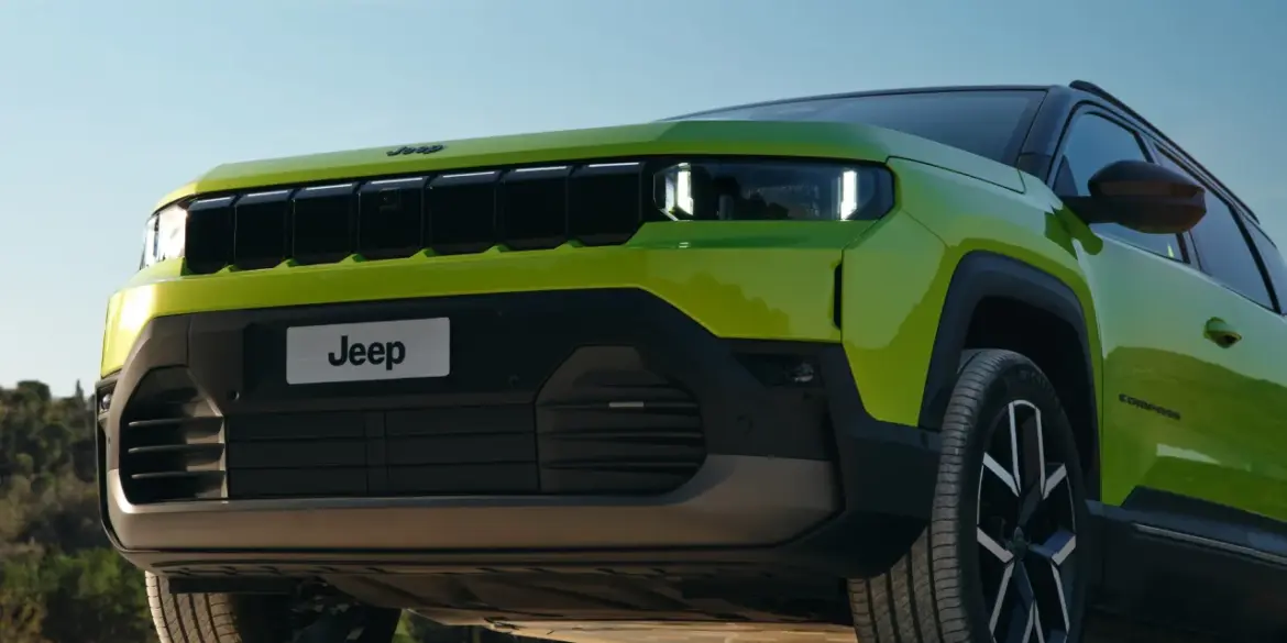 Frontansicht des Jeep Compass e-Hybrid in Grün mit markantem Kühlergrill und LED-Scheinwerfern